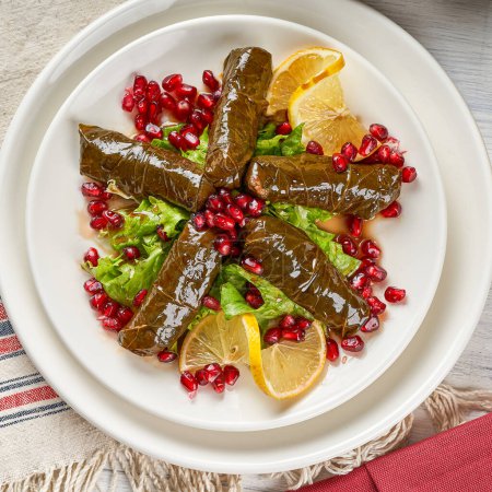 Foto de Rollos de hojas de uva rellenos de arroz y carne, un plato popular de aperitivo turco-árabe - Imagen libre de derechos