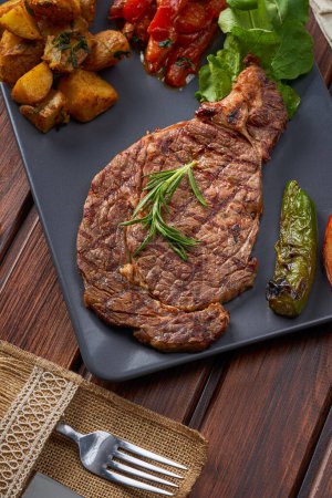 Foto de Primer plano de un plato de bistec con patatas y verduras a la parrilla Con romero - Imagen libre de derechos