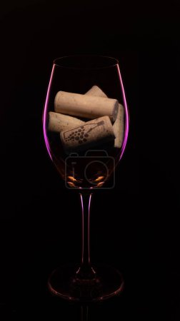 Photo for Wine glass with tap of bottles - Royalty Free Image