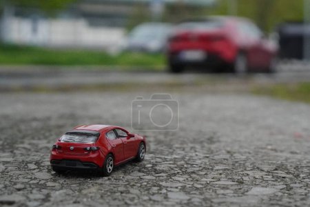 model mazda 3 car from HotWheels with a real japanese Mazda 3 car in red colour
