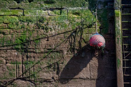 Téléchargez les photos : Mur dans un port avec une boule orange flottante en Normandie France - en image libre de droit