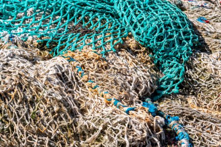 Old fishing nets piled together on a port in Normandy, France