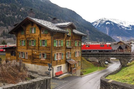 Foto de Una casa en el pueblo o Trun en Suiza con un tren que pasa - Imagen libre de derechos