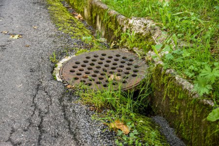 Photo for Old metal drainage lid or manhole by the roads of Braunwalt in Switzerland - Royalty Free Image