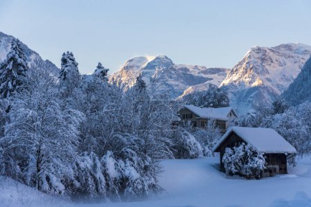 Winter landscape in Glarus Sud with Chalets and farms with mount Todi, in the Alps, in the background