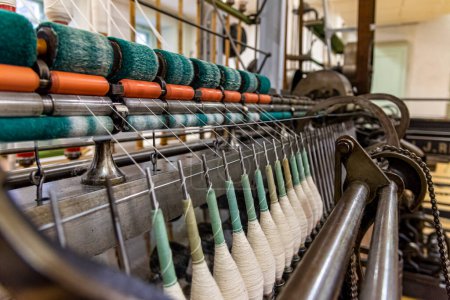Foto de Maquinaria de hilado antigua que trabaja en una fábrica textil vieja - Imagen libre de derechos