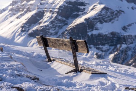 banco de madera en los Alpes en invierno