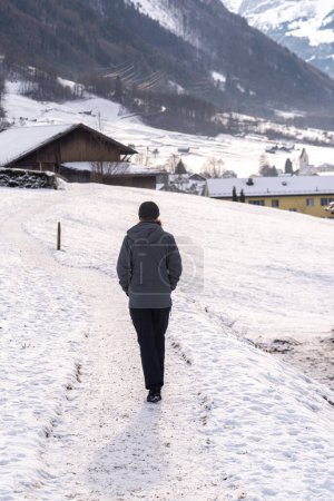 Téléchargez les photos : Femme marchant sur un sentier enneigé en Suisse - en image libre de droit