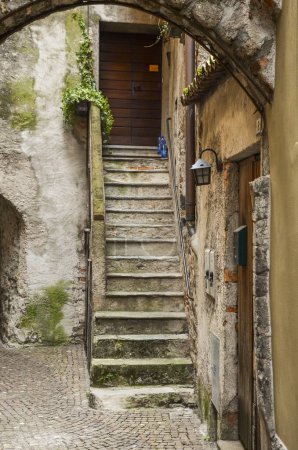 Foto de Calle estrecha con una antigua escalera en porleza, italia - Imagen libre de derechos