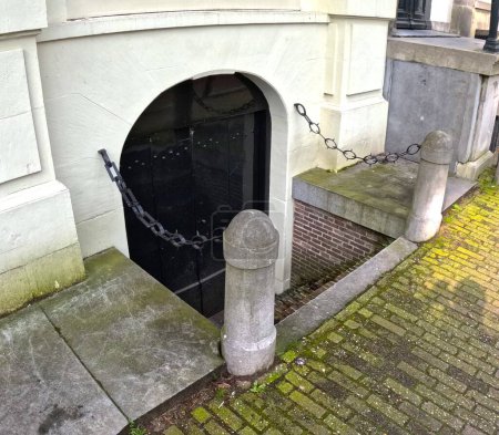 Un disparo vertical de una vieja puerta en la ciudad de Amsterdam, Países Bajos.Puerta de entrada a la bodega en Ams. Holanda
