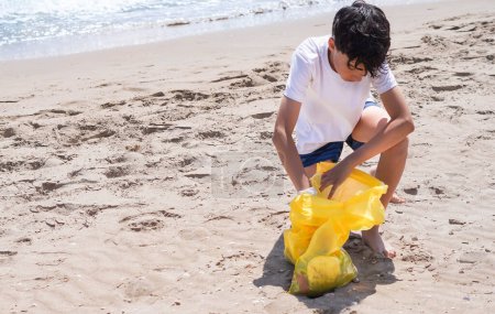 pre-teen picking up plastics on the beach
