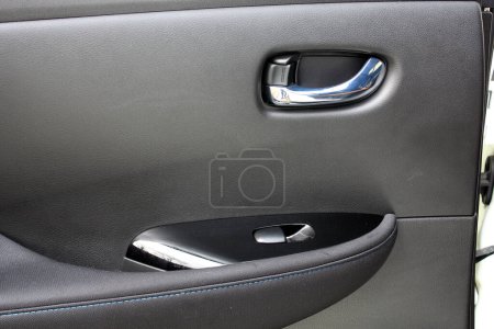 Electric Car door trim with windows control. Car Inside Door Handle Interior. Leather Door trim. Rear door trim of a Electric car. Electric Car interior.