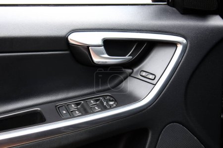 Window control buttons in modern SUV. Car leather interior details of door handle with windows controls and adjustments. Modern SUV leather Interior.