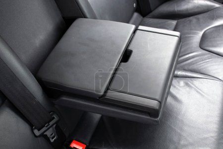Modern car central armrest for rear seat passengers. Rear passenger armrest. Leather passenger seats with armrest.