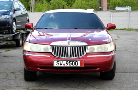 Téléchargez les photos : Vinnytsia, Ukraine ; 20 avril 2024. Red stretch limousine Lincoln Town Voiture la rue de la ville. Voiture américaine classique Lincoln Town Car au parking. Vue de face. - en image libre de droit