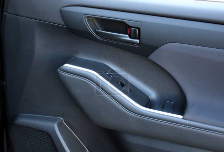 Premium SUV inside door handle. SUV door control panel. Window lifters control. Armrest with setting adjustment button and blocking the opening and closing of doors. Door trim.
