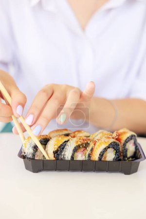 Téléchargez les photos : Sushi roll Philadelphie au saumon, anguille fumée, avocat, fromage à la crème sur fond noir. Menu sushi. Nourriture japonaise - en image libre de droit