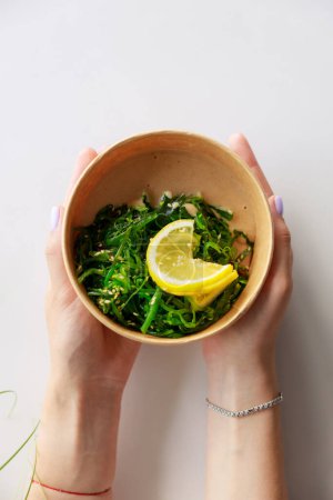 Hiyashi Wakame Salad In Kraft Food Delivery Container In Female Hands, Chuka Salad,