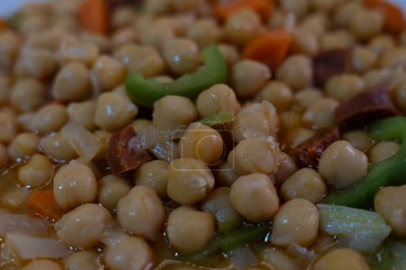 Closeup of cooked chickpeas with pepper and carrot. Traditional mediterranean recipe