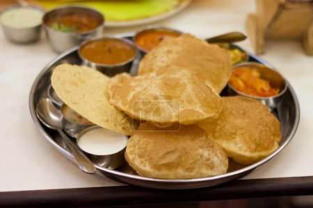 Savouring Spice: Puri Bhaji Delight.Crisp, golden puris, freshly fried to perfection, accompany a fragrant and spicy potato bhaji. With each bite, experience a symphony of textures and aromas.