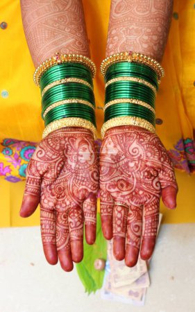 Téléchargez les photos : Un beau design de henné est l'ornement et le maquillage préférés des femmes indiennes pour des occasions spéciales. Les mains d'une mariée sont recouvertes de henné tatoué artistiquement fait par des spécialistes. - en image libre de droit