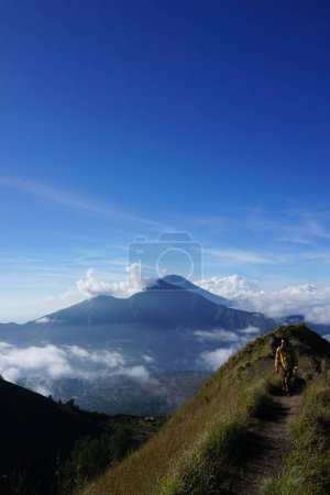 Photo for Peak Paradise, Asian Model on Mount Batur Summit with Ocean of Clouds under Azure Sky - Royalty Free Image