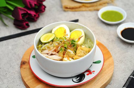 Photo for Soto comes from Chinese food in the Hokkian dialect Cau do, Jao To, or Chau Tu, which means 'grass' or 'spice offal'. served on white bowl with tofu, chicken and boiled egg - Royalty Free Image