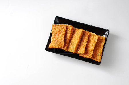 Photo for Fried tempeh served on a black plate, isolated white background, food traditional concept - Royalty Free Image