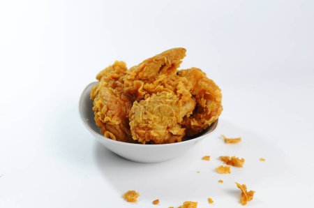 Foto de Pollo frito servido en un tazón blanco, fondo blanco aislado, concepto de comida - Imagen libre de derechos