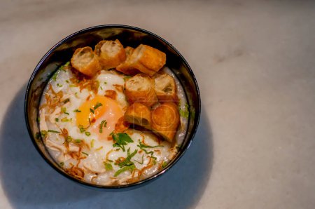 Photo for Chicken porridge with half boiled egg and cuake - Royalty Free Image
