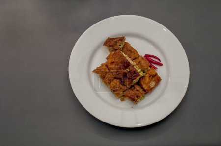 Murtabak is often described as spicy folded omelette pancake with bits of vegetables.