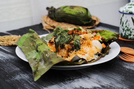 Nasi bakar (Indonesian for "burned or grilled rice") refers to steamed rice seasoned with spices and ingredients and wrapped in banana leaf secured with lidi semat (