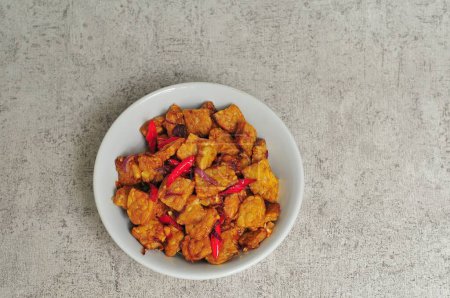 Sweet fried tempeh served in a white bowl