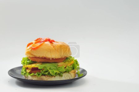 Photo for Burger filled with green vegetables on a black plate - Royalty Free Image