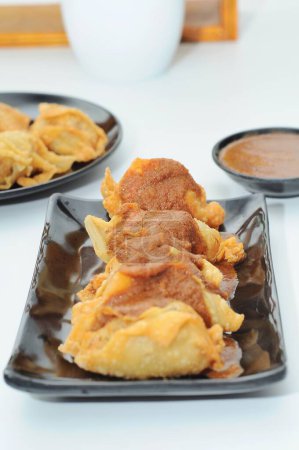 Photo for Batagor (abbreviated from Baso Tahu Gorng, "fried bakso and tofu") is a Sundanese dish from Indonesia, and popular in Southeast Asia, consisting of fried fish dumplings, usually served with peanut sauce - Royalty Free Image