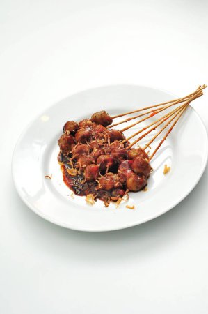 Photo for Grilled meatballs on a plate of puti, spicy sauce and peanut sauce - Royalty Free Image