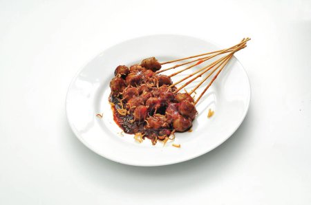 Téléchargez les photos : Boulettes de viande grillées sur une assiette de puti, sauce épicée et sauce aux arachides - en image libre de droit