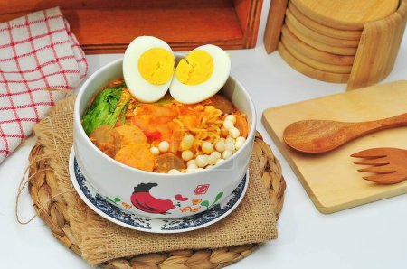 Nourriture indonésienne Nourriture traditionnelle de Java occidental, le nom est seblak, fabriqué à partir de craquelins humides cuits avec de la sauce épicée, servis sur un bol blanc qui a un motif de poulet