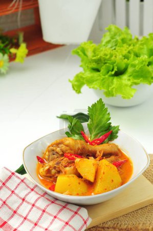 Foto de Curry de pollo servido en un tazón blanco con fondo bokeh - Imagen libre de derechos