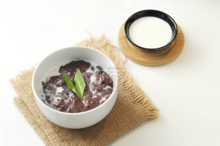 Téléchargez les photos : Porridge de riz gluant noir ou Bubur Pulut Hitam en malais avec du lait de coco sur fond blanc - en image libre de droit