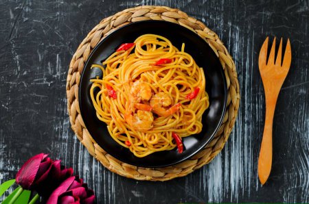 Photo for Italian pasta with seafood and shrimps in a black plate. - Royalty Free Image