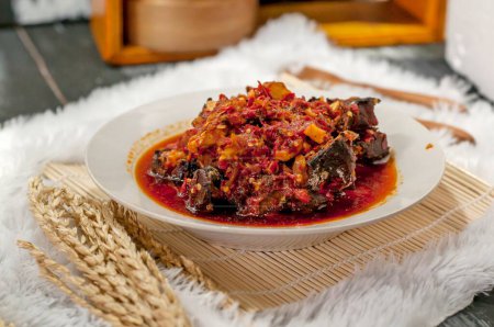 Téléchargez les photos : Sardines à la sauce rouge sur une assiette blanche avec fond bokeh clair - en image libre de droit