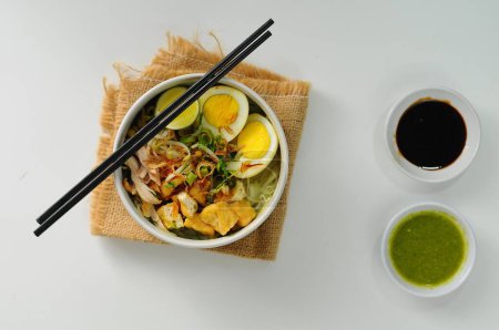 Photo for Soto comes from Chinese food in the Hokkian dialect Cau do, Jao To, or Chau Tu, which means 'grass' or 'spice offal'. served on white bowl with tofu, chicken and boiled egg - Royalty Free Image
