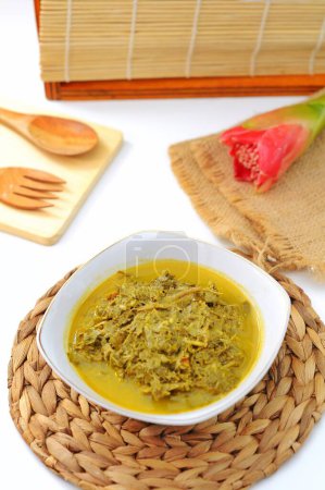 Photo for Daun ubi tumbuk (Indonesian for "pounded cassava leaves") is a vegetable dish commonly found in Indonesia, made from pounded cassava leaves. In Indonesian, daun means leaf, ubi refers to cassava, and - Royalty Free Image