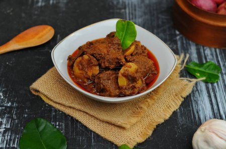 Photo for Rendang Jengkol, dogfruit simmered in spices and coconut milk. Indonesian traditional food, with a spicy savory taste typical of rendang and a legit jengkol texture - Royalty Free Image