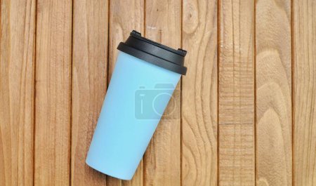 Photo for Plastic drinking water container with light blue citizens and black lid on a wooden table - Royalty Free Image