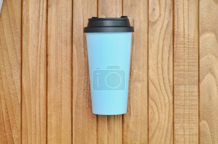 Photo for Plastic drinking water container with light blue citizens and black lid on a wooden table - Royalty Free Image