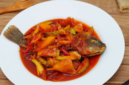 Photo for Deep Fried Tilapia Fish topped Sweet and sour sauce, served on white plate - Royalty Free Image