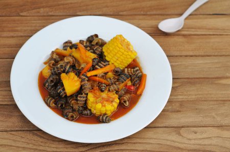 Téléchargez les photos : Escargots cuits avec une sauce aigre-douce, servis sur une assiette blanche - en image libre de droit