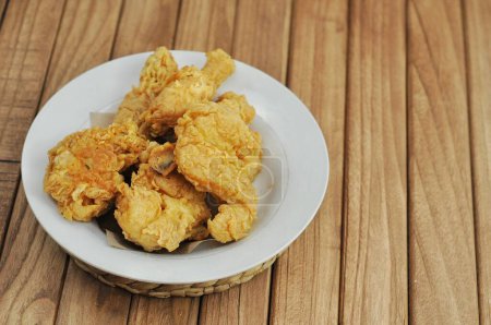 Photo for Crispy fried chicken served on a white plate on a wooden table - Royalty Free Image